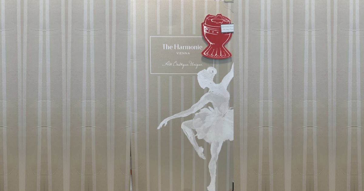 Titelseite der Speisekarte des Boutiquehotels The Harmonie Vienna mit handgemalter weißer Ballerina, rotem Pauken-Emblem und dem Schriftzug „Art. Boutique. Unique.